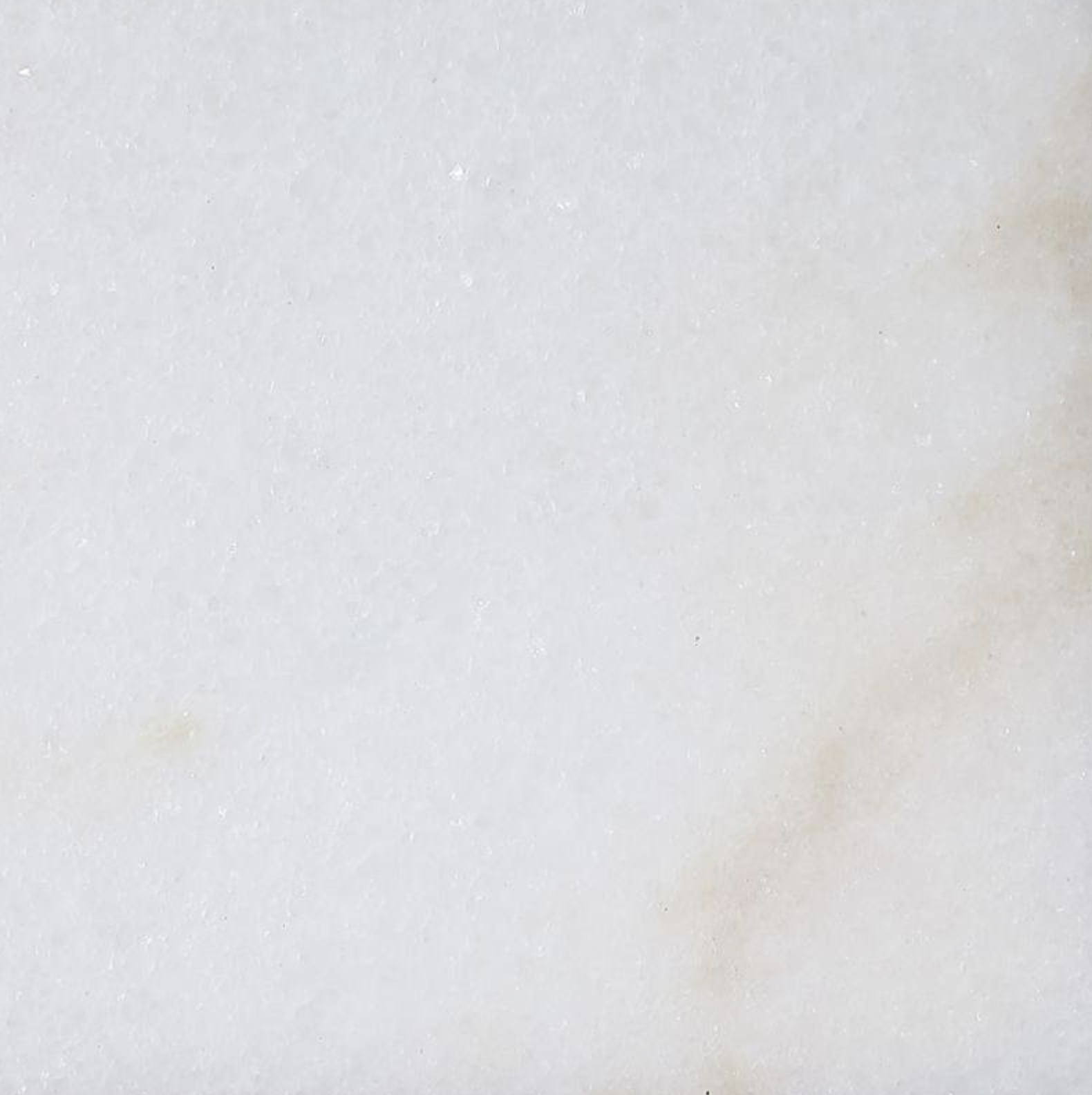 Close-up of a white textured surface, possibly paper or foam, with some small faint stains or marks.