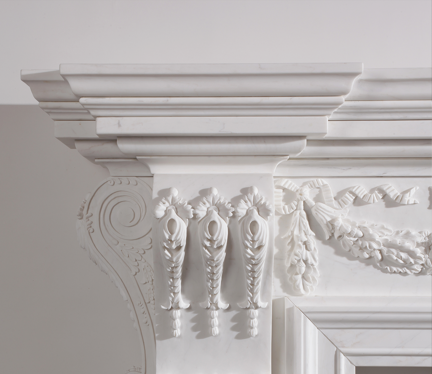 White marble fireplace with ornate carved details, including floral and scroll motifs.
