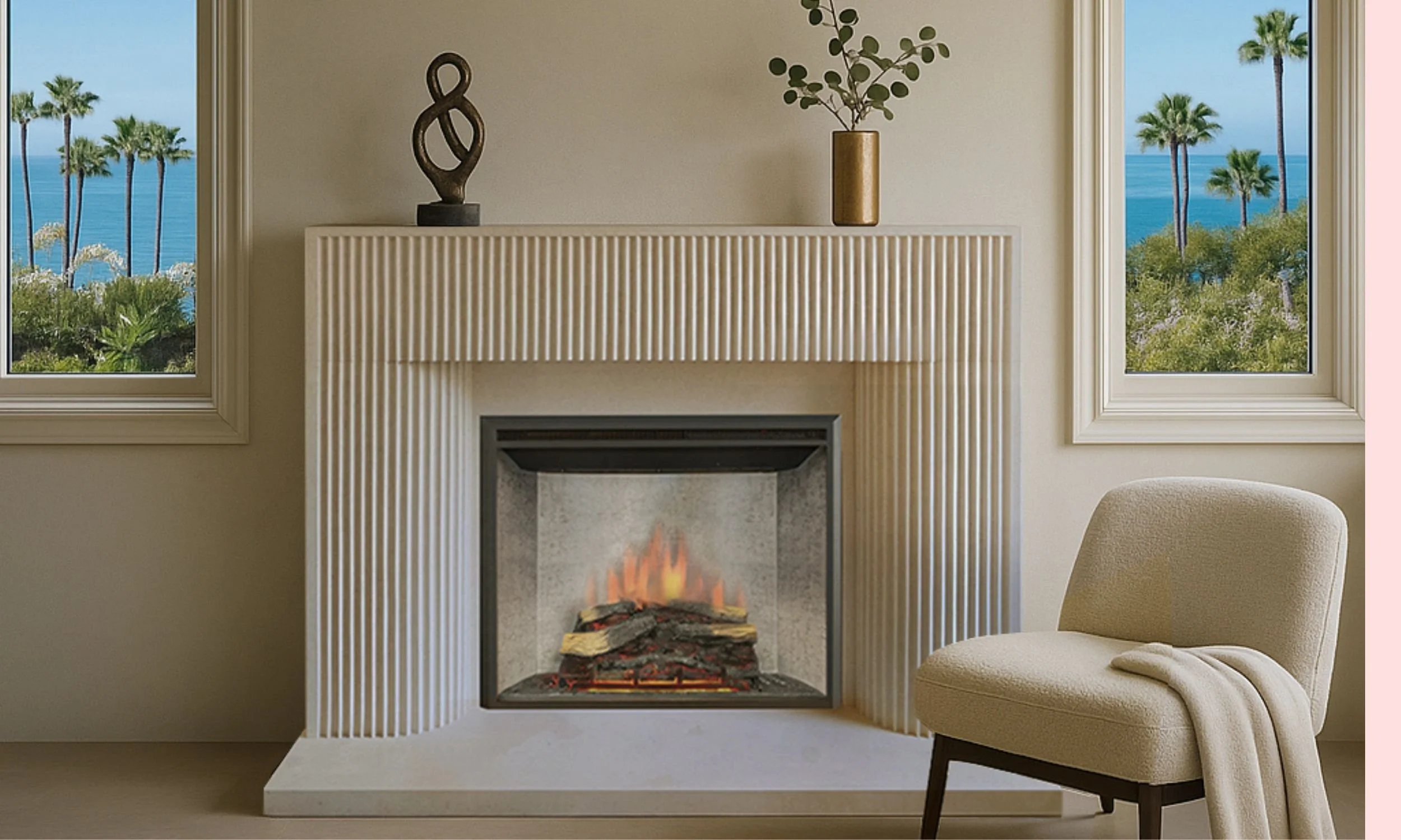 Living room with a fireplace, beige armchair with a blanket, two windows showing a view of palm trees and the ocean, and decorative objects on the mantelpiece.