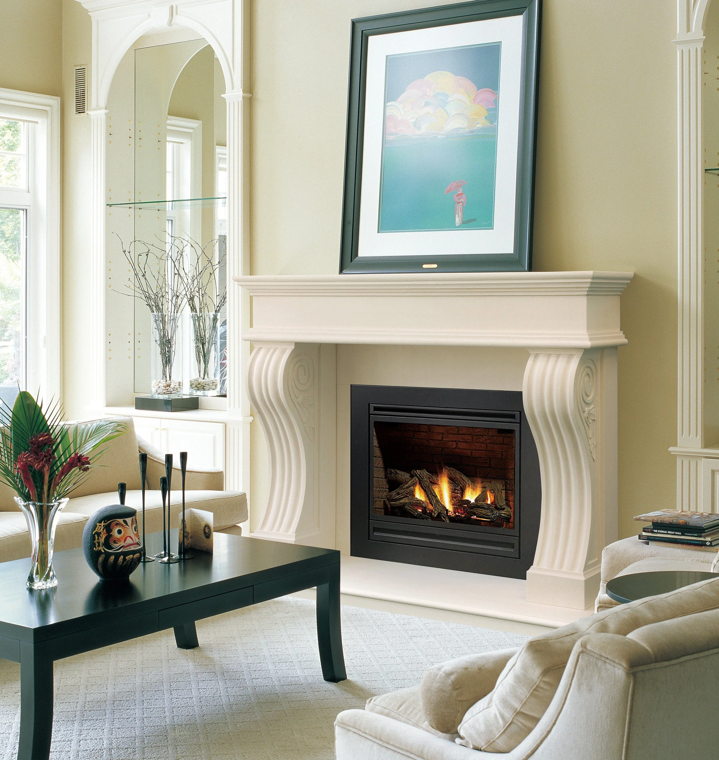 Living room with a white fireplace, a framed artwork above it, a black coffee table with a vase and decorative objects, and a beige armchair.