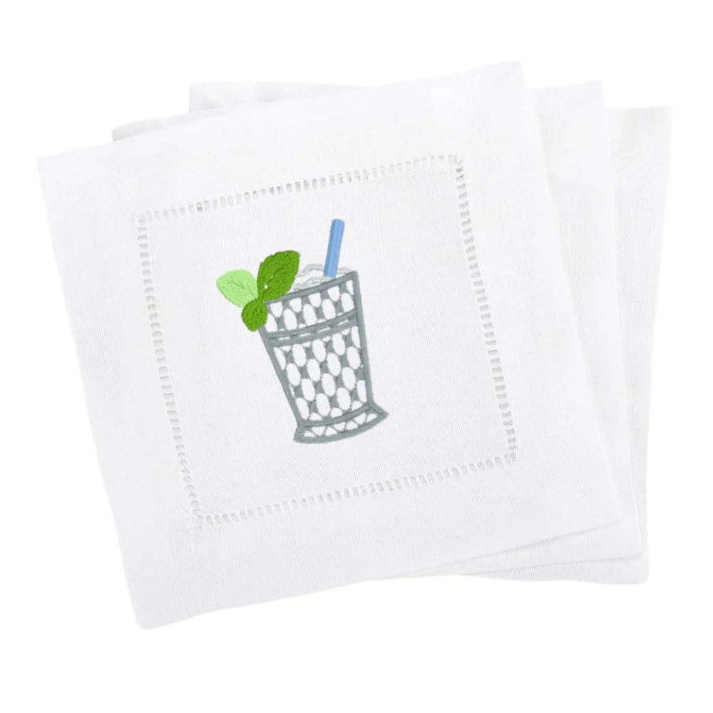 White napkin with embroidered design of a glass of a beverage with a straw and mint leaves.