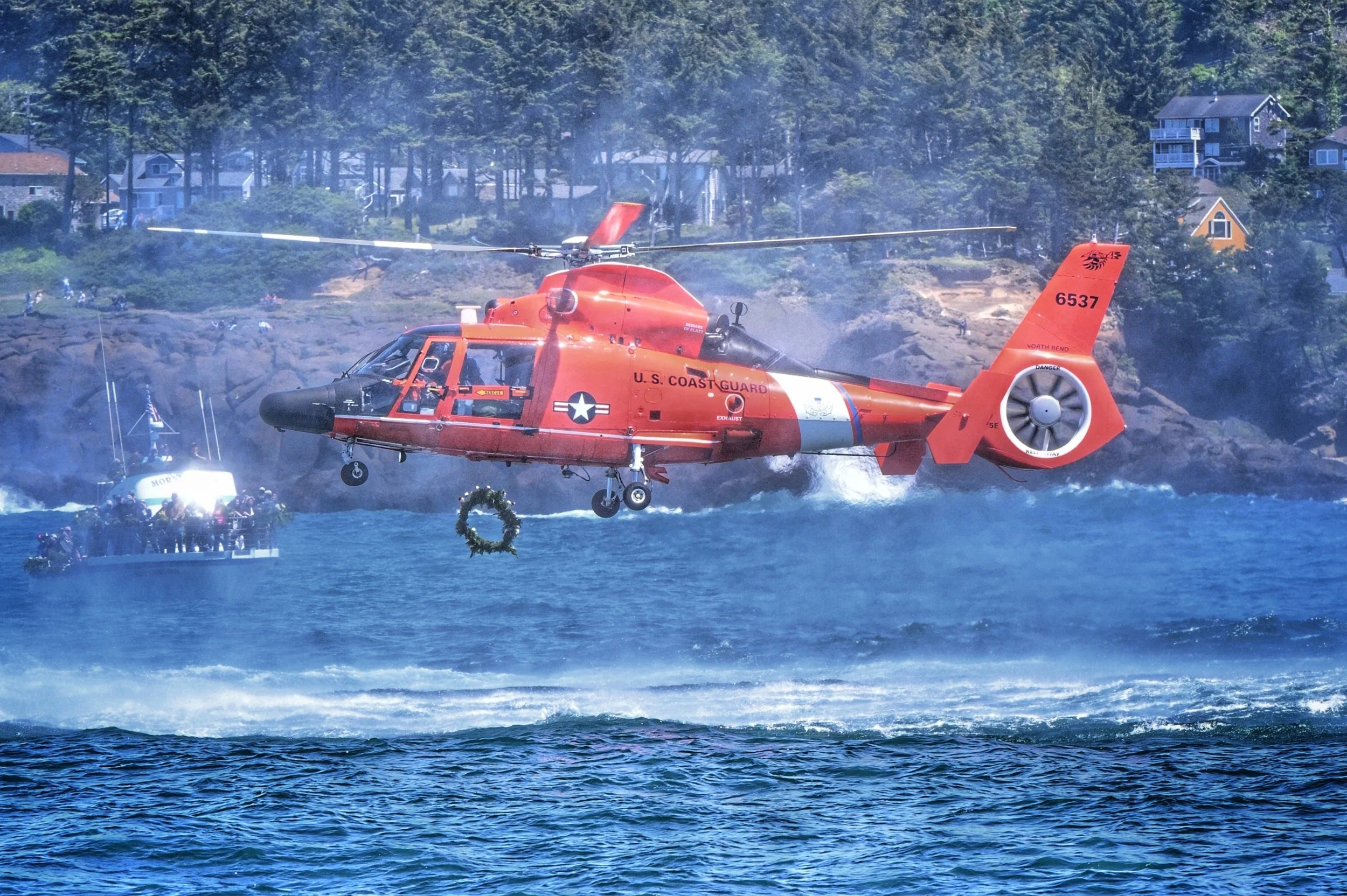 A helicopter dropping a floral wreath at Fleet of flowers in Depoe Bay, Oregon