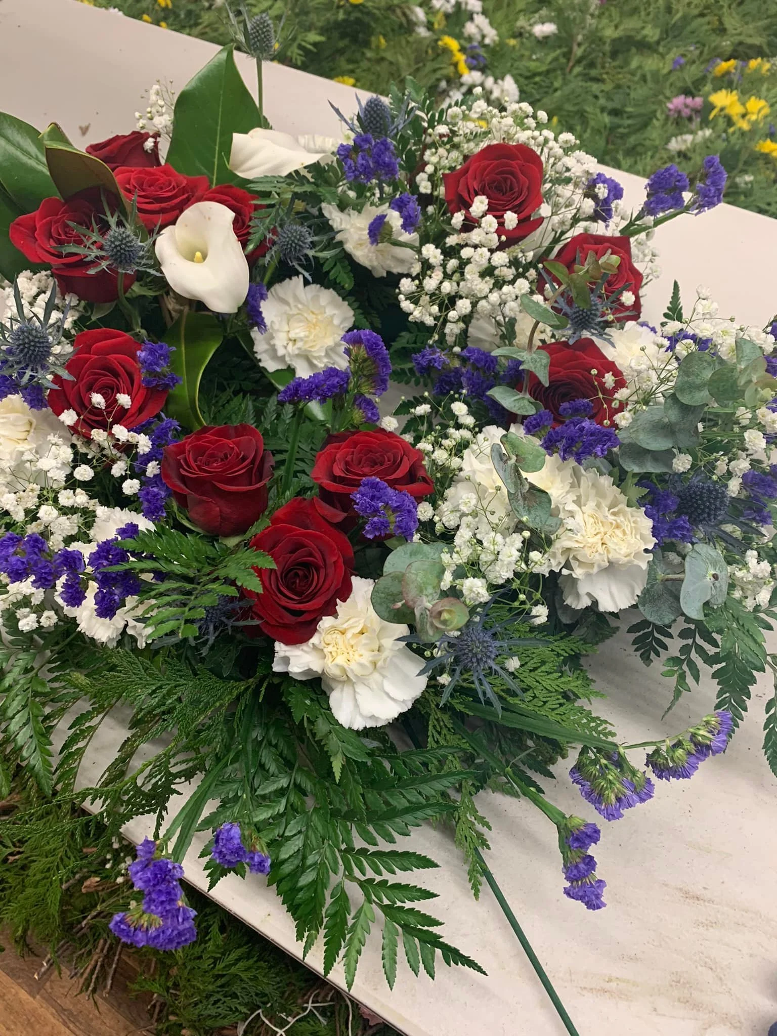 A wreath decorated with white, red, and purple flowers