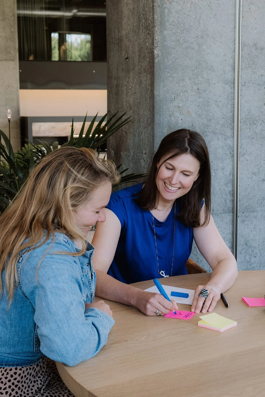 Twee vrouwen schrijven ideeën op tijdens een brainstormsessie.