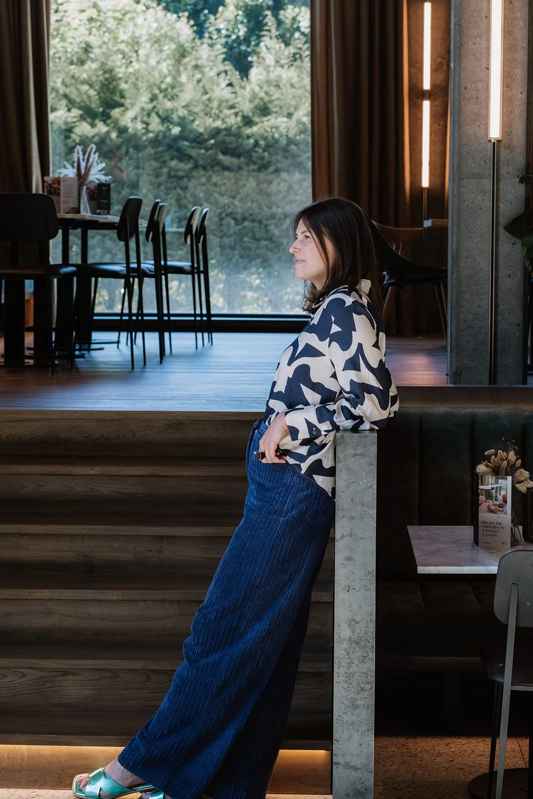 Vrouw die in een inspirerende setting staat, klaar voor een transformatie in haar bedrijf.