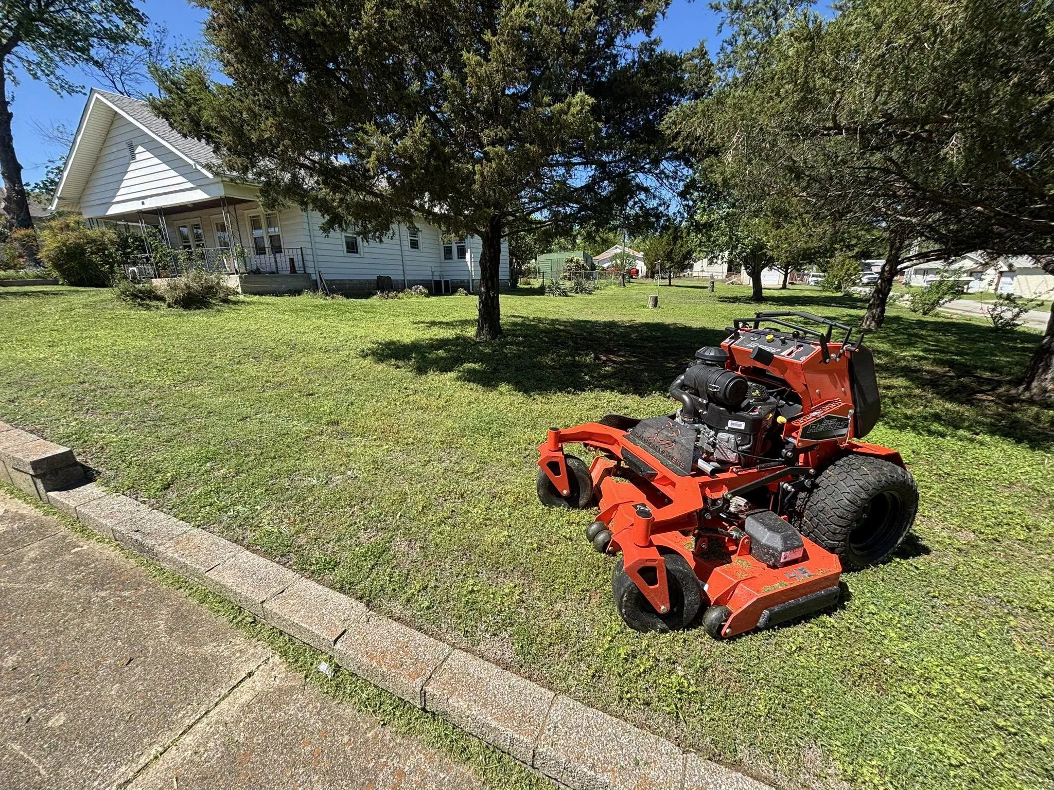 Mid-service progress photo showing active lawn maintenance in Drumright, OK, with professional equipment and efficient route-based service.