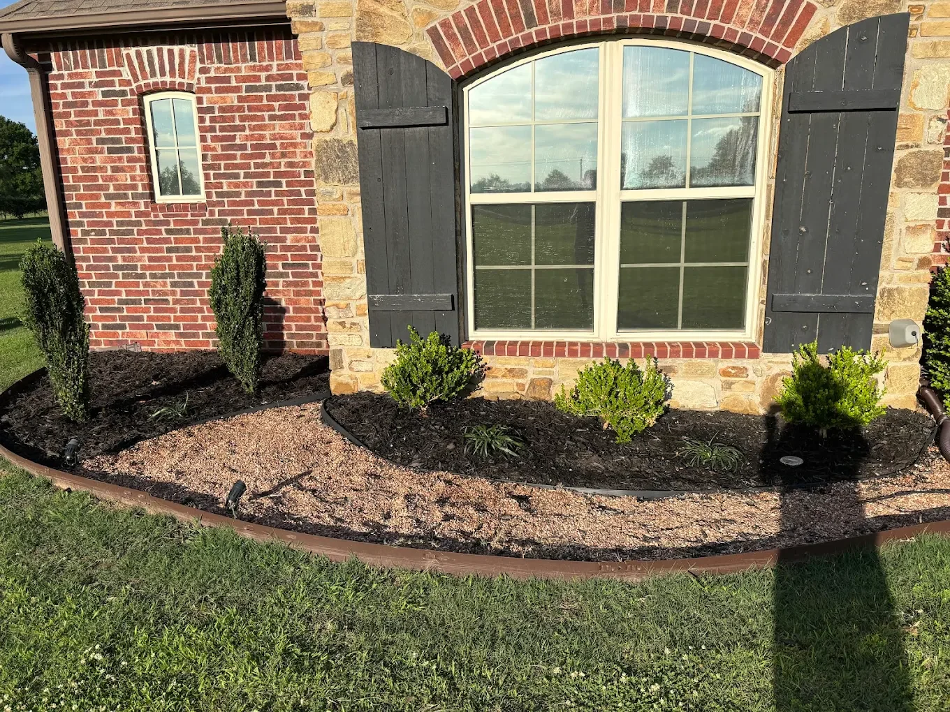 Fresh mulch and thoughtfully placed landscape plants installed to refresh the existing beds and keep the home looking sharp.