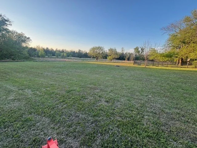 Large residential property maintained with clean, even mowing and consistent coverage across open acreage.