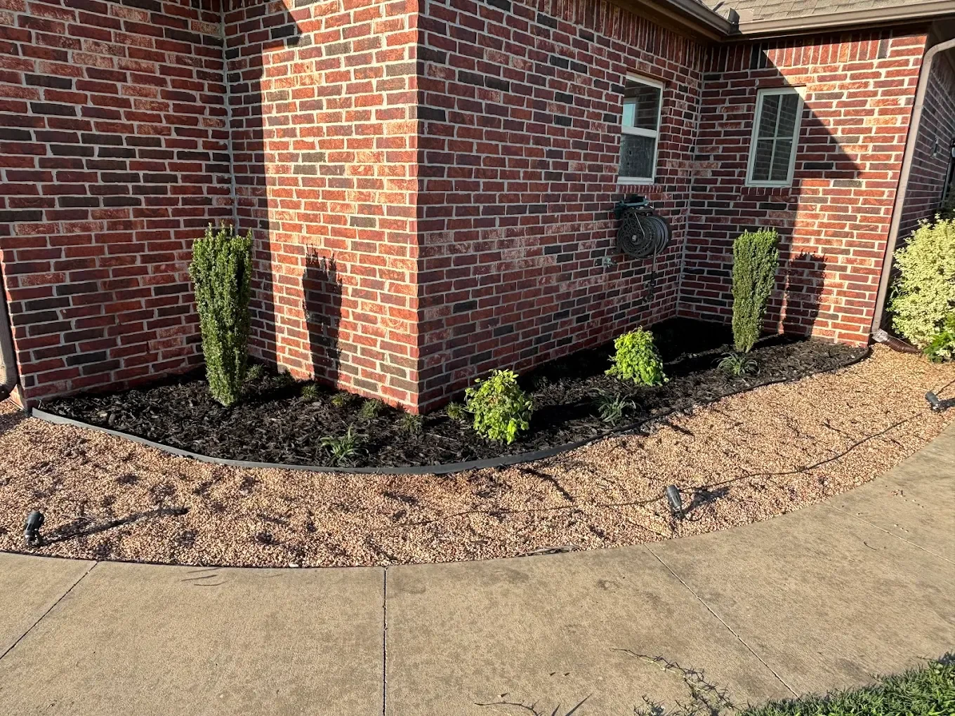 New plant installation paired with fresh mulch to add color, structure, and a clean finished look around the home.