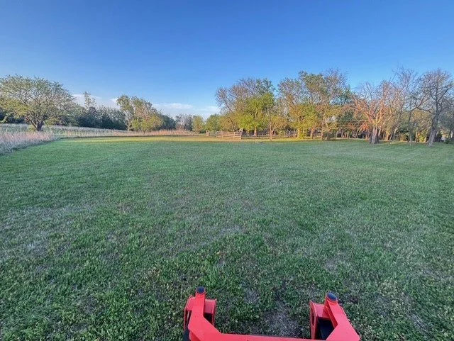 Even, full-property mowing with attention to detail across fence lines and open lawn areas.
