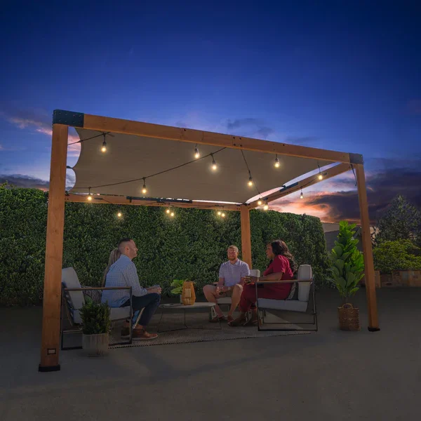 Backyard Discovery pergola with canopy and string lights creating an evening patio seating area