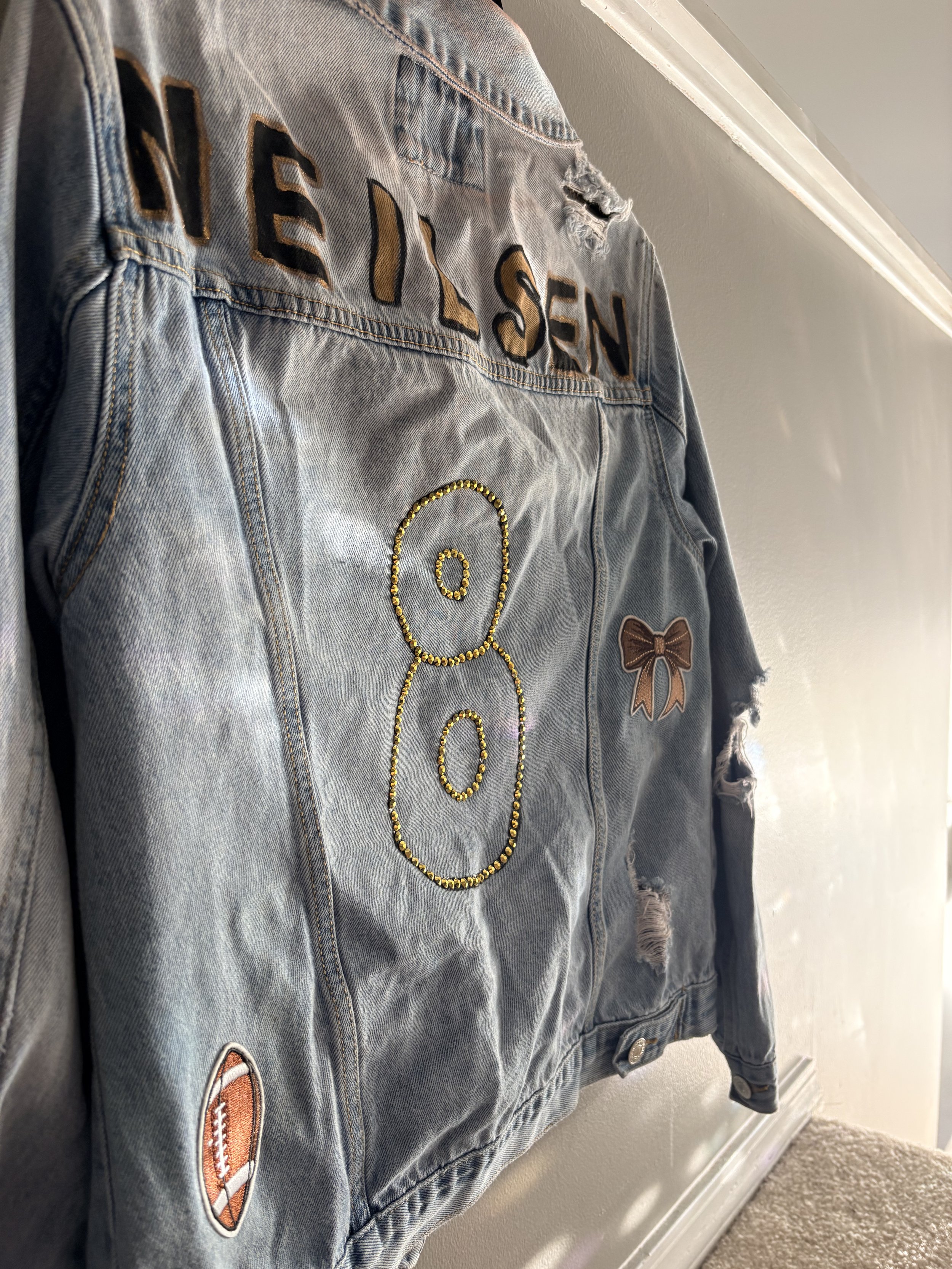 Light wash denim jacket. Includes patches, painted, and rhinestones