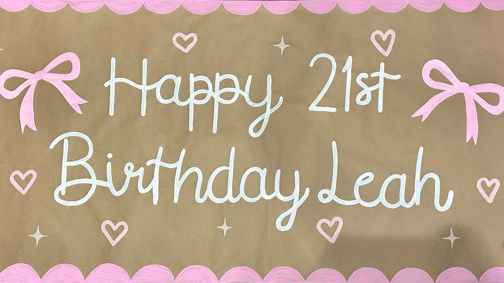 A decorated birthday poster with pink bows, pink hearts, and a pink scalloped border, celebrating Leah's 21st birthday.