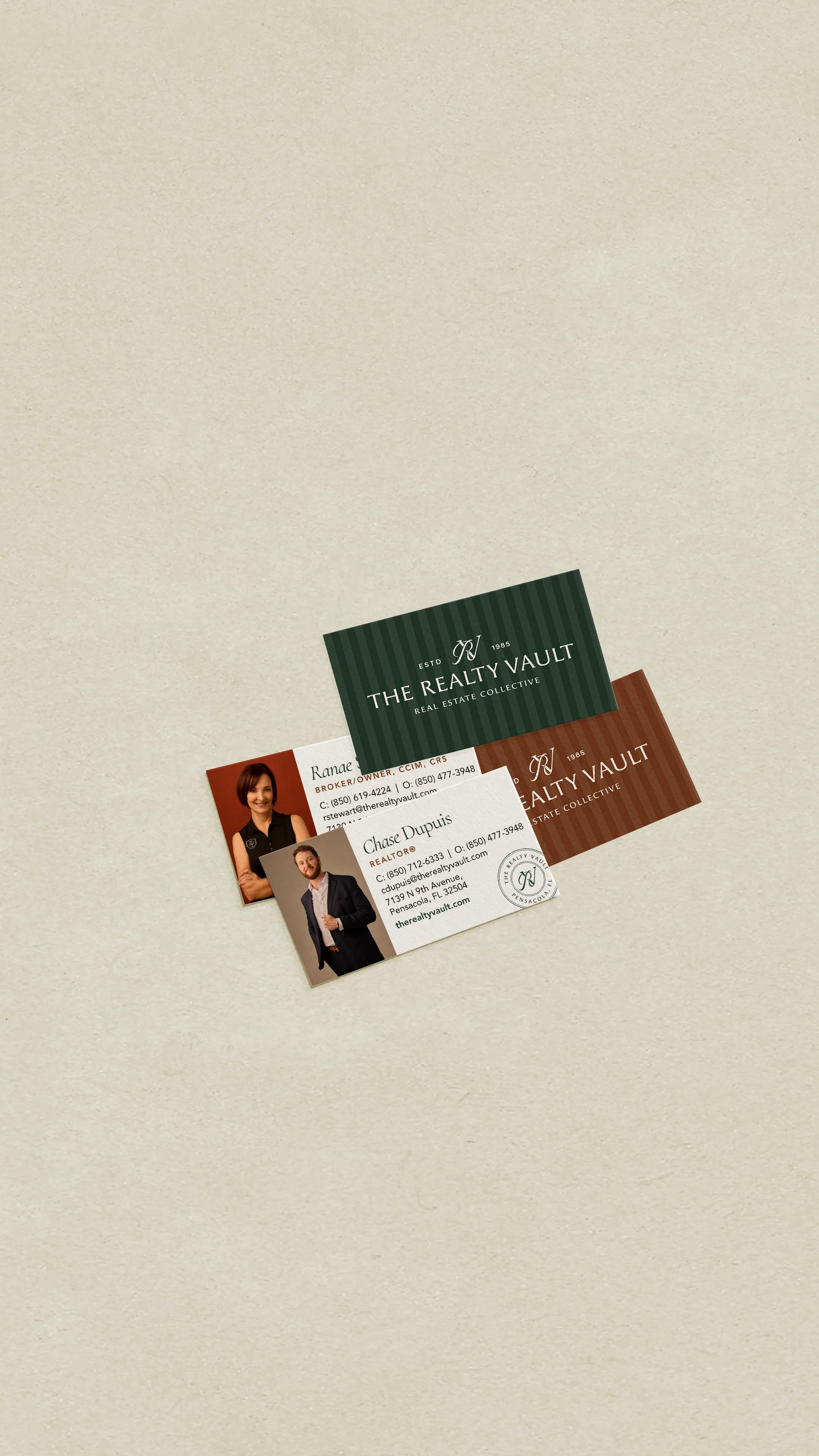 Business cards for real estate agents Ranee and Chase Dupuis from The Realty Vault, displayed on a beige surface.