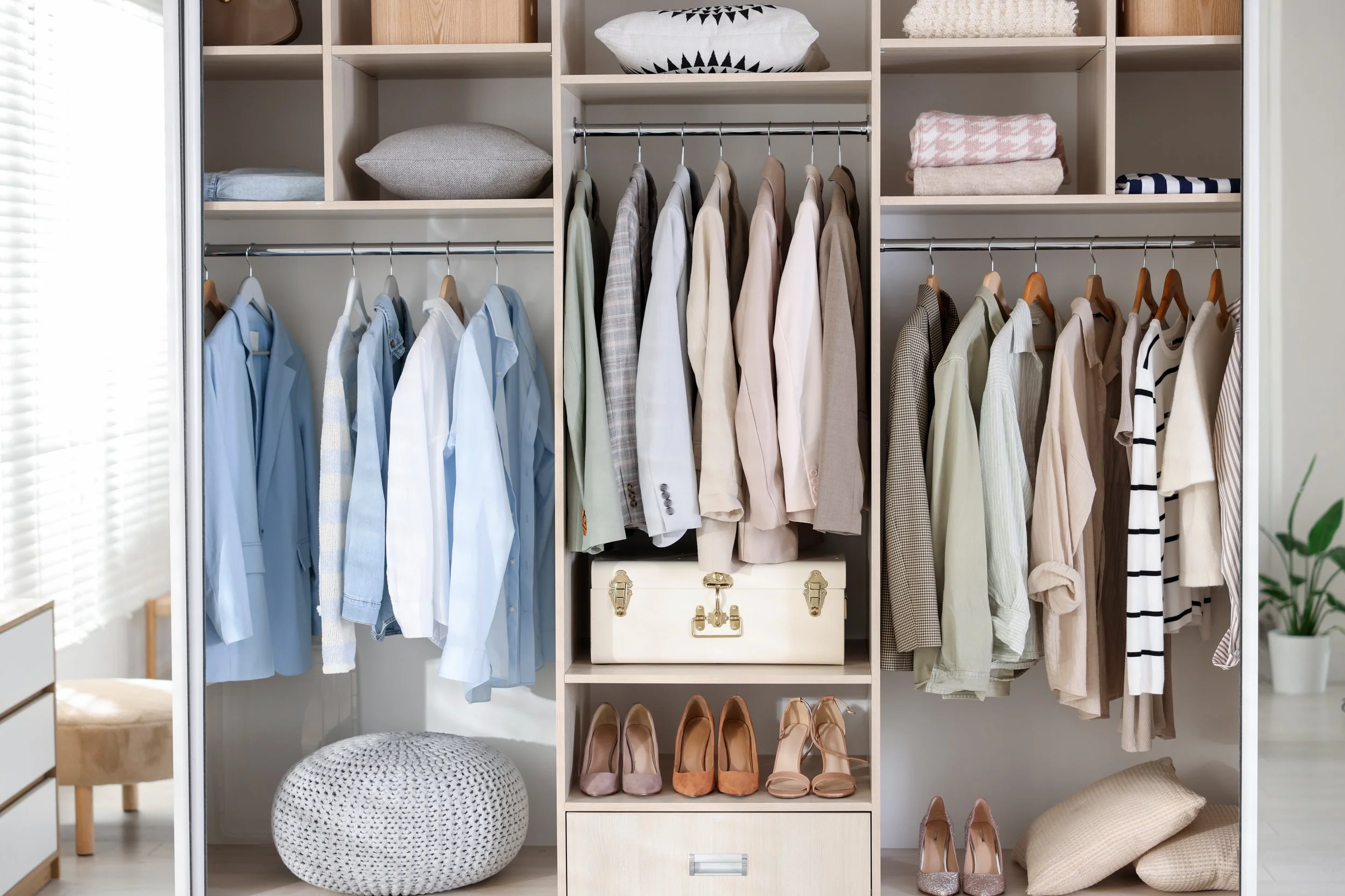 Open closet with clothing, shoes, and accessories neatly organized on shelves and hangers.