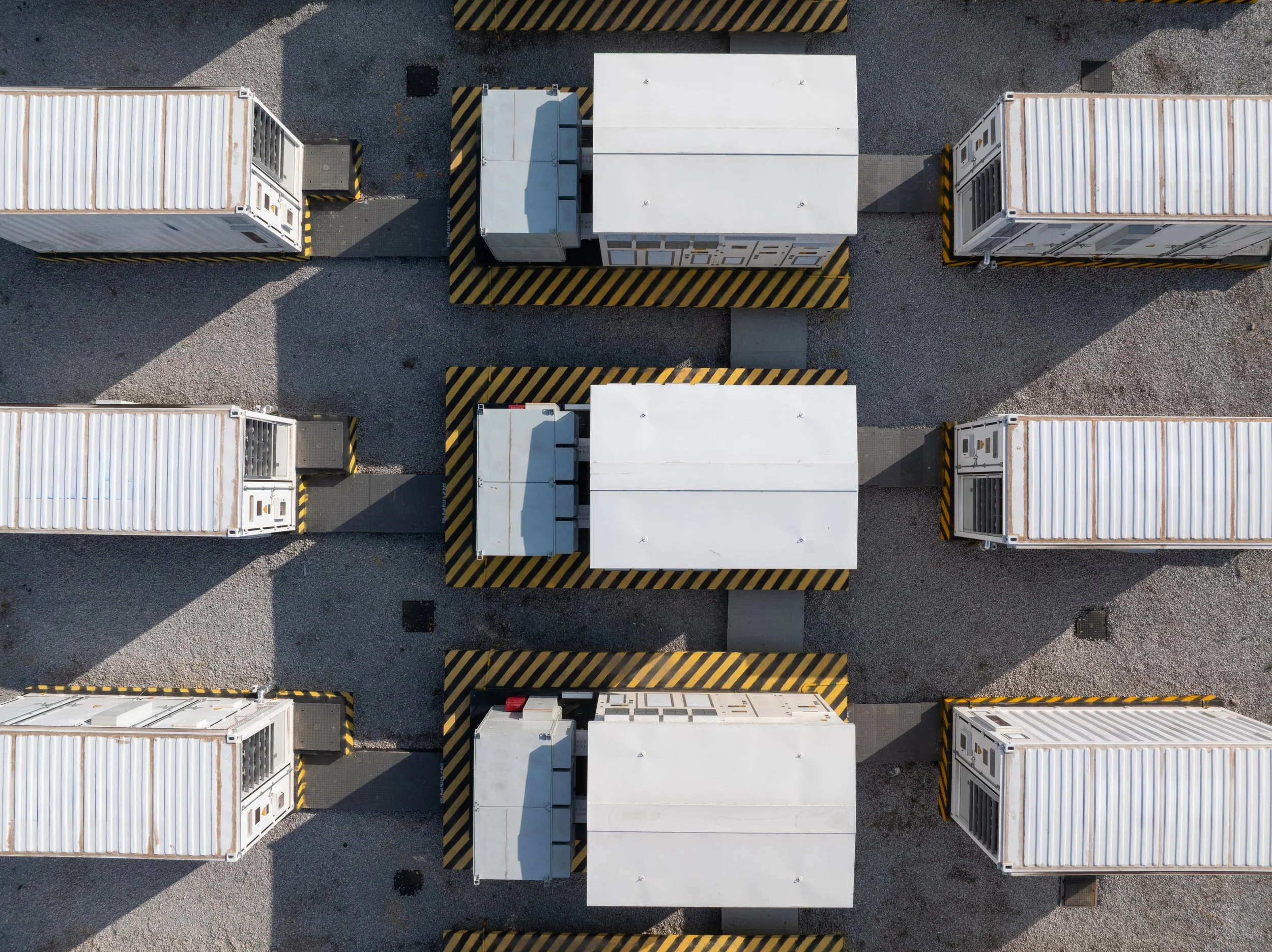 Top-down view of Battery Energy Storage System comprising several white shipping containers arranged in rows