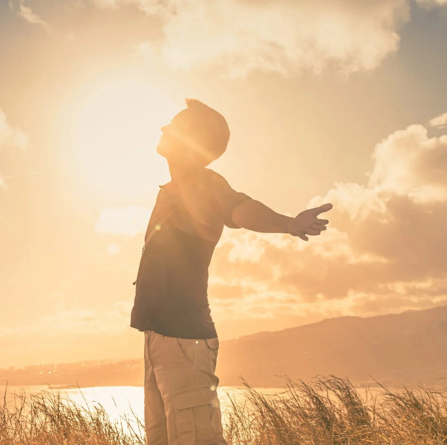 Understanding Stress & Trauma - A person standing outdoors at sunset.