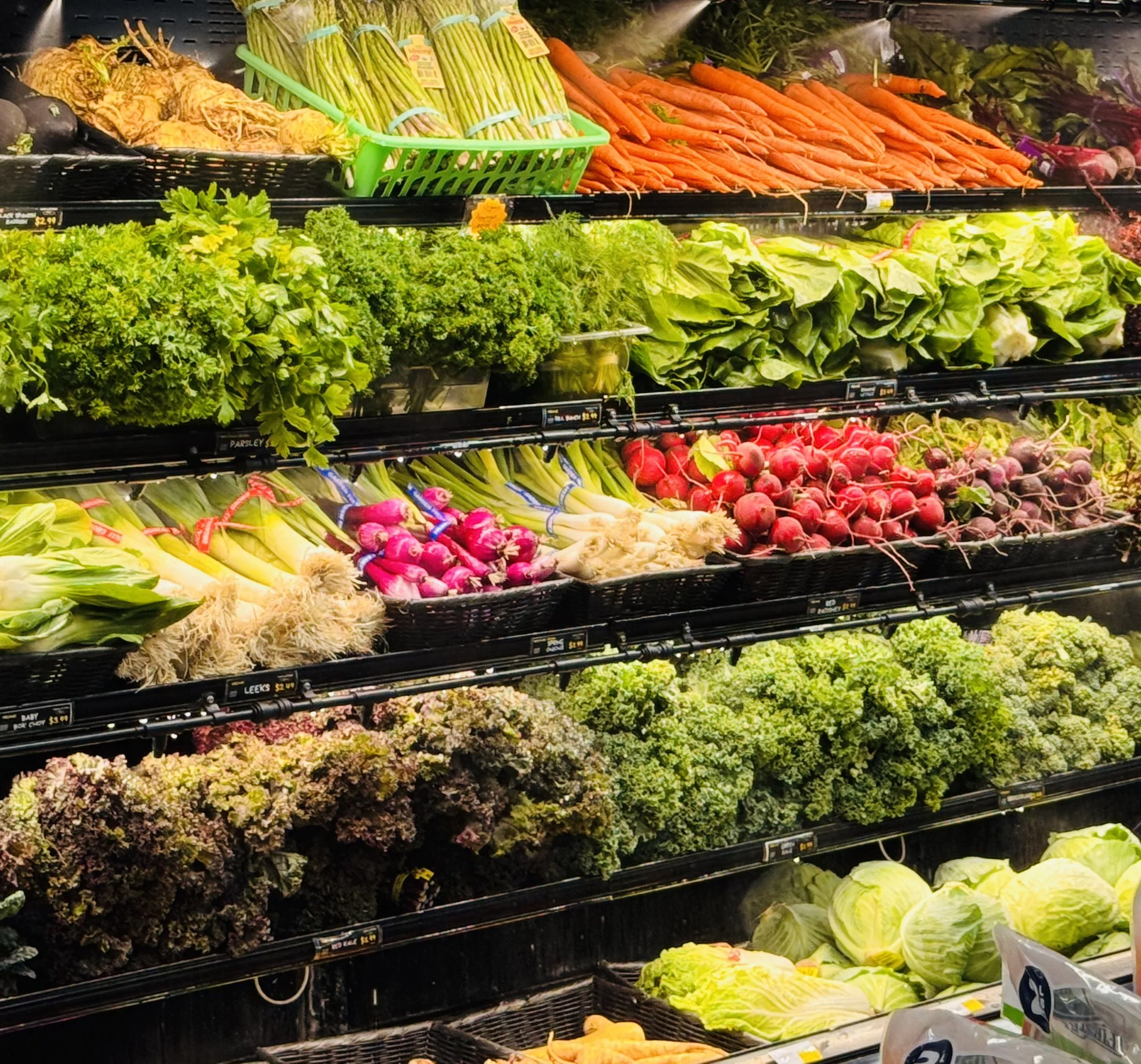 Merrill's produce cooler freshly stocked with leafy greens and root veggies.