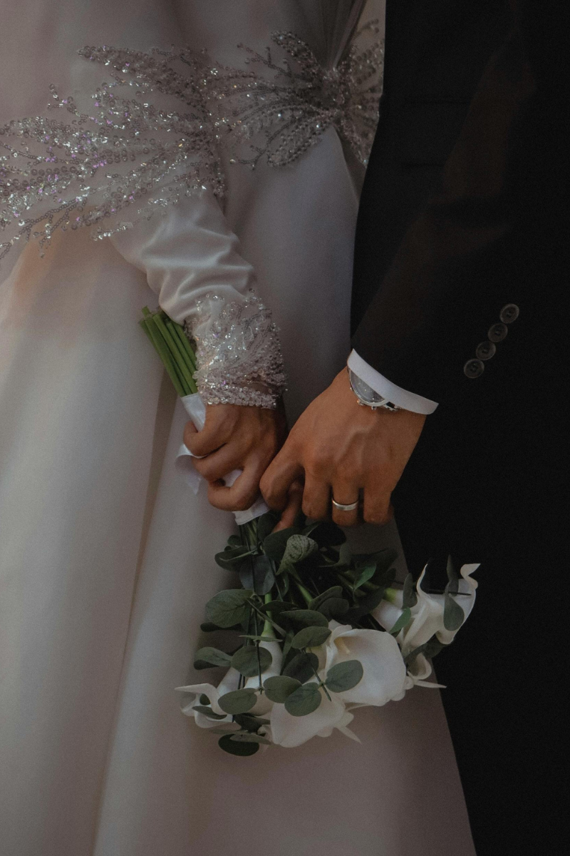 couple holding the bouquet on their wedding day