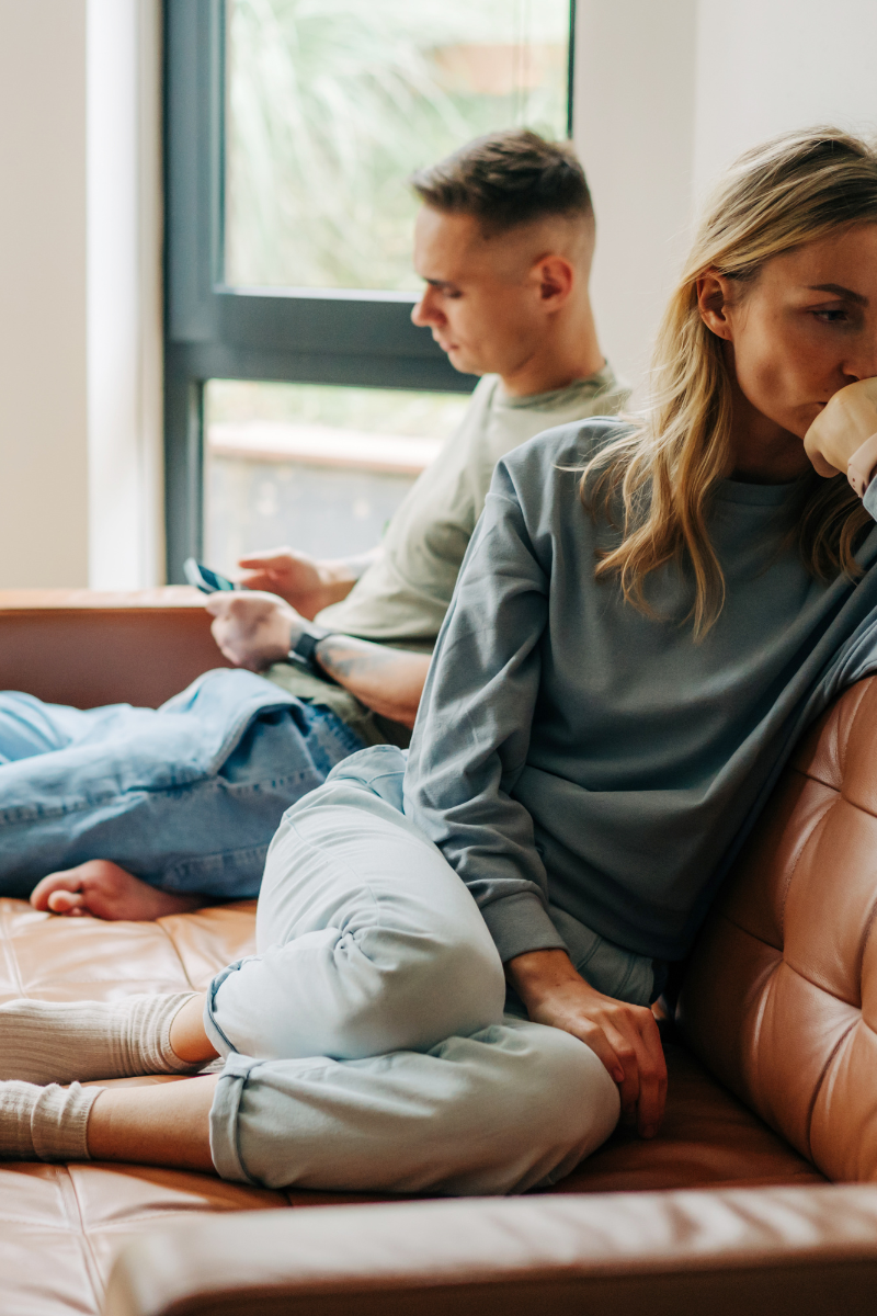 couple sitting on the couch, upset with one another