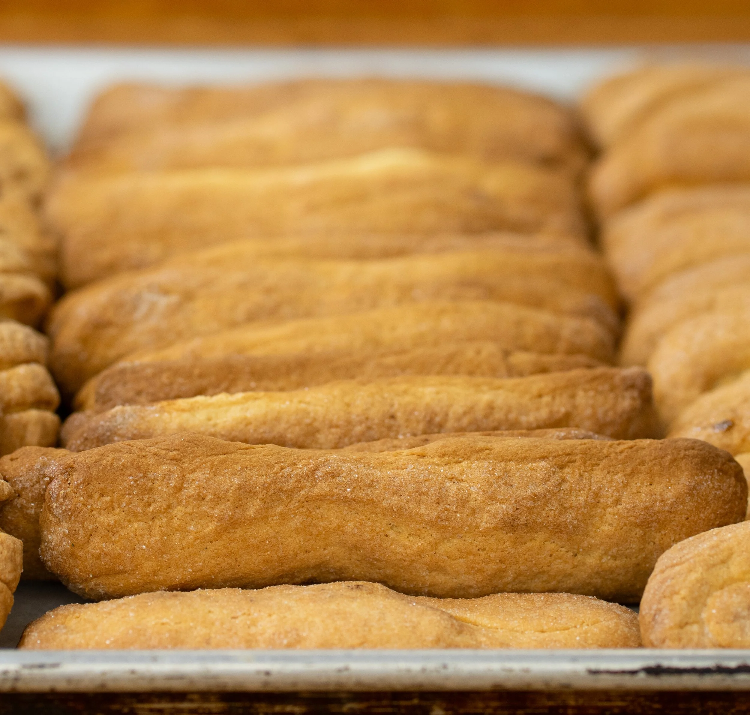 Close-up of fried chicken tenders stacked on a tray.