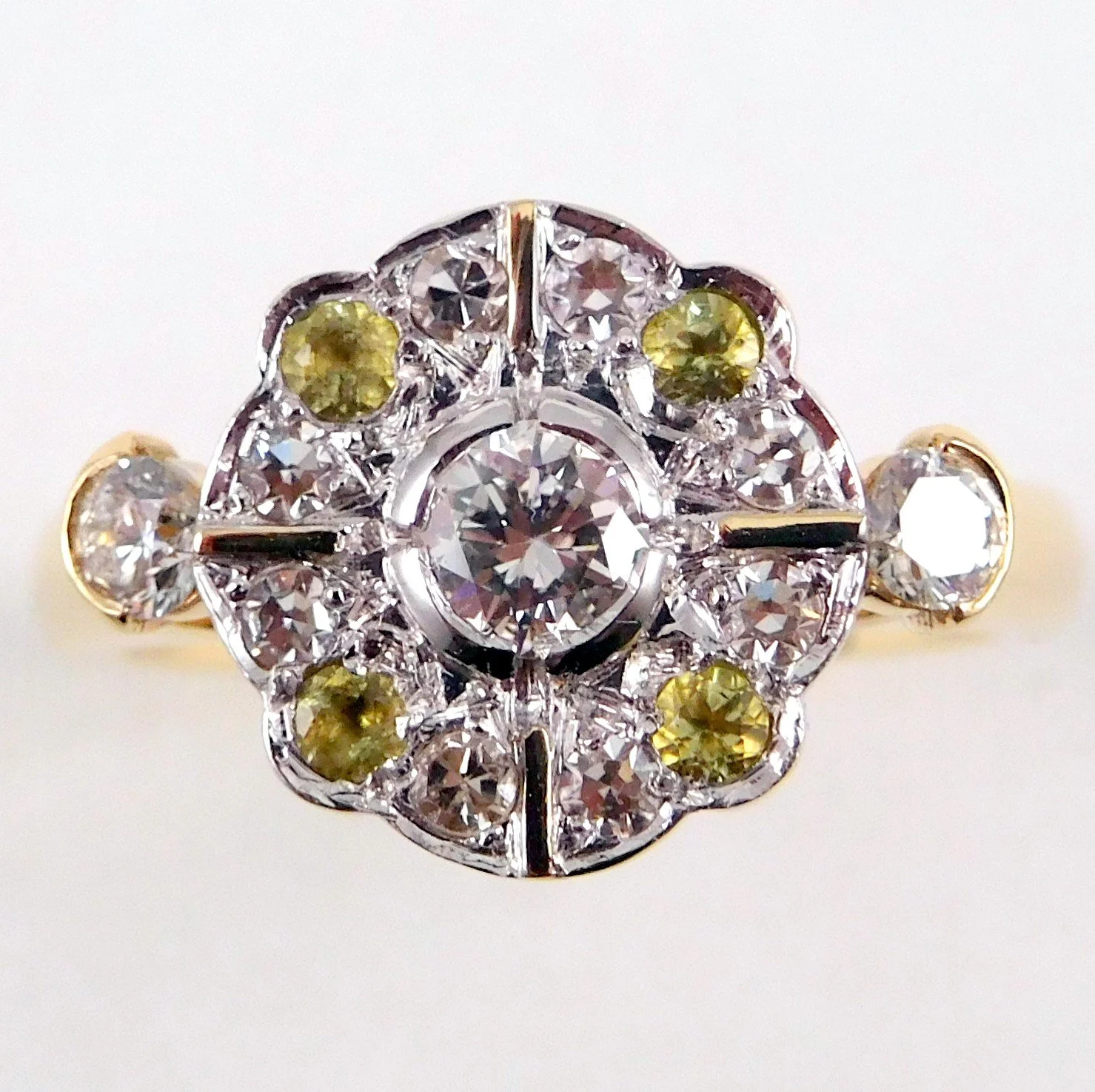 Close-up of a decorative ring with clear and yellow gemstones, set in a gold band.