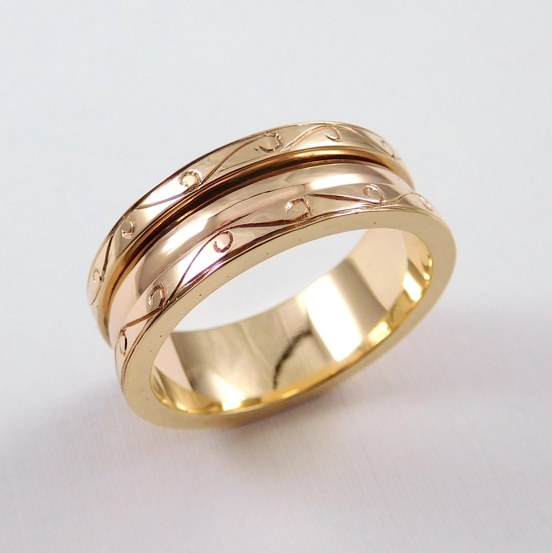 Gold wedding band with engraved patterns. 