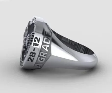 A silver graduation ring with an engraved graduation date of '28-12' and the word 'GRADE A' on it.