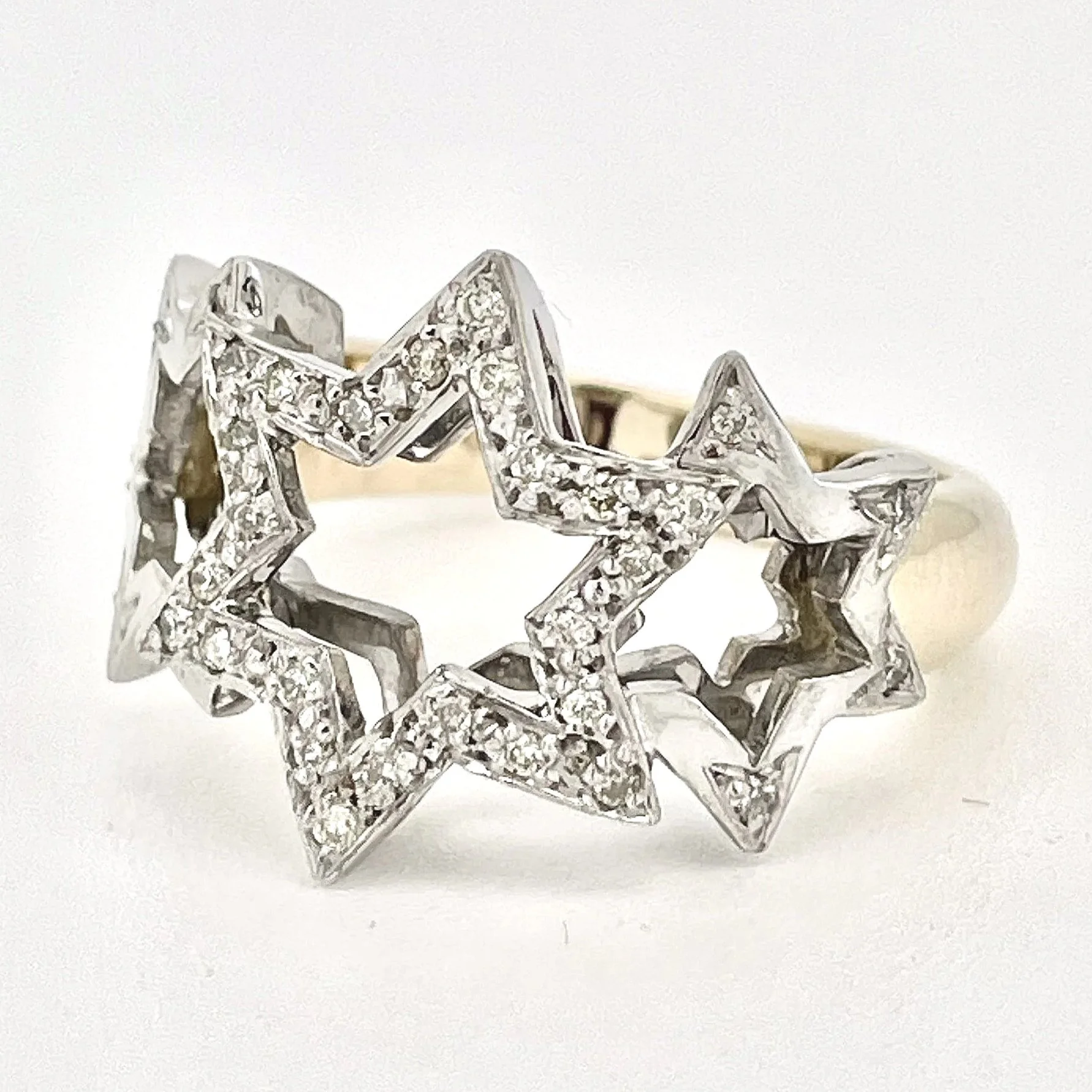 Silver ring with multiple star-shaped designs, encrusted with small diamonds or crystals, set against a plain white background.