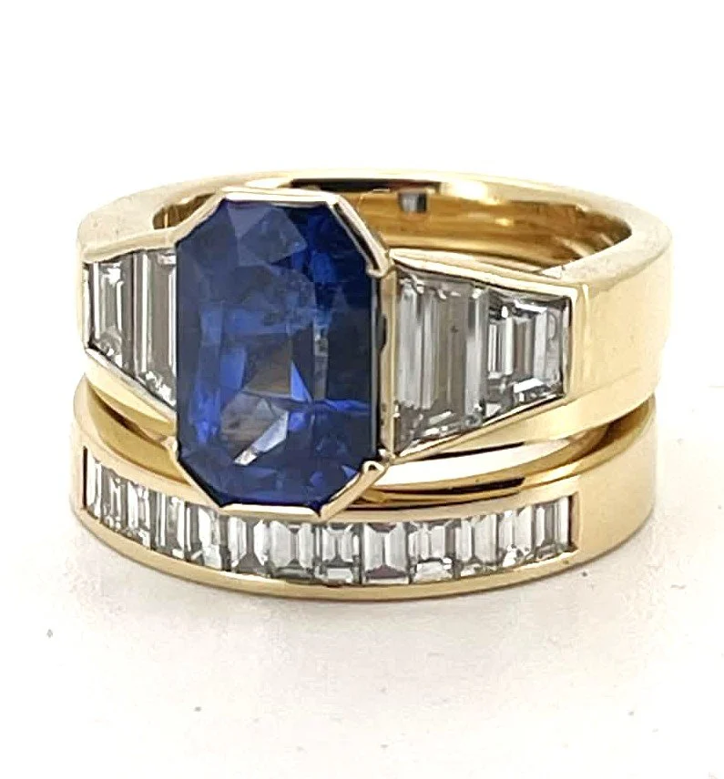 Gold ring with a large oval blue sapphire gemstone and baguette-cut diamonds on the band.