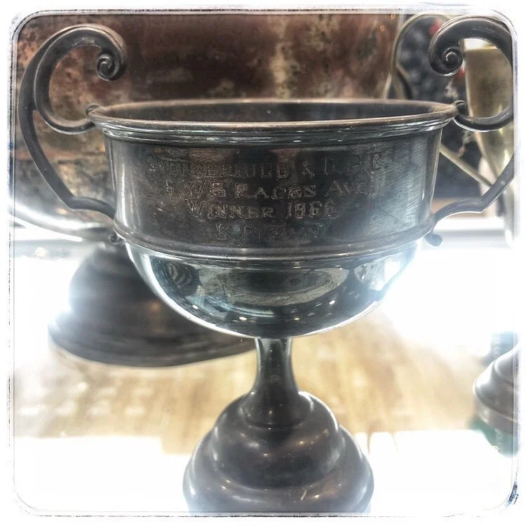 A silver trophy cup needing cleaning.