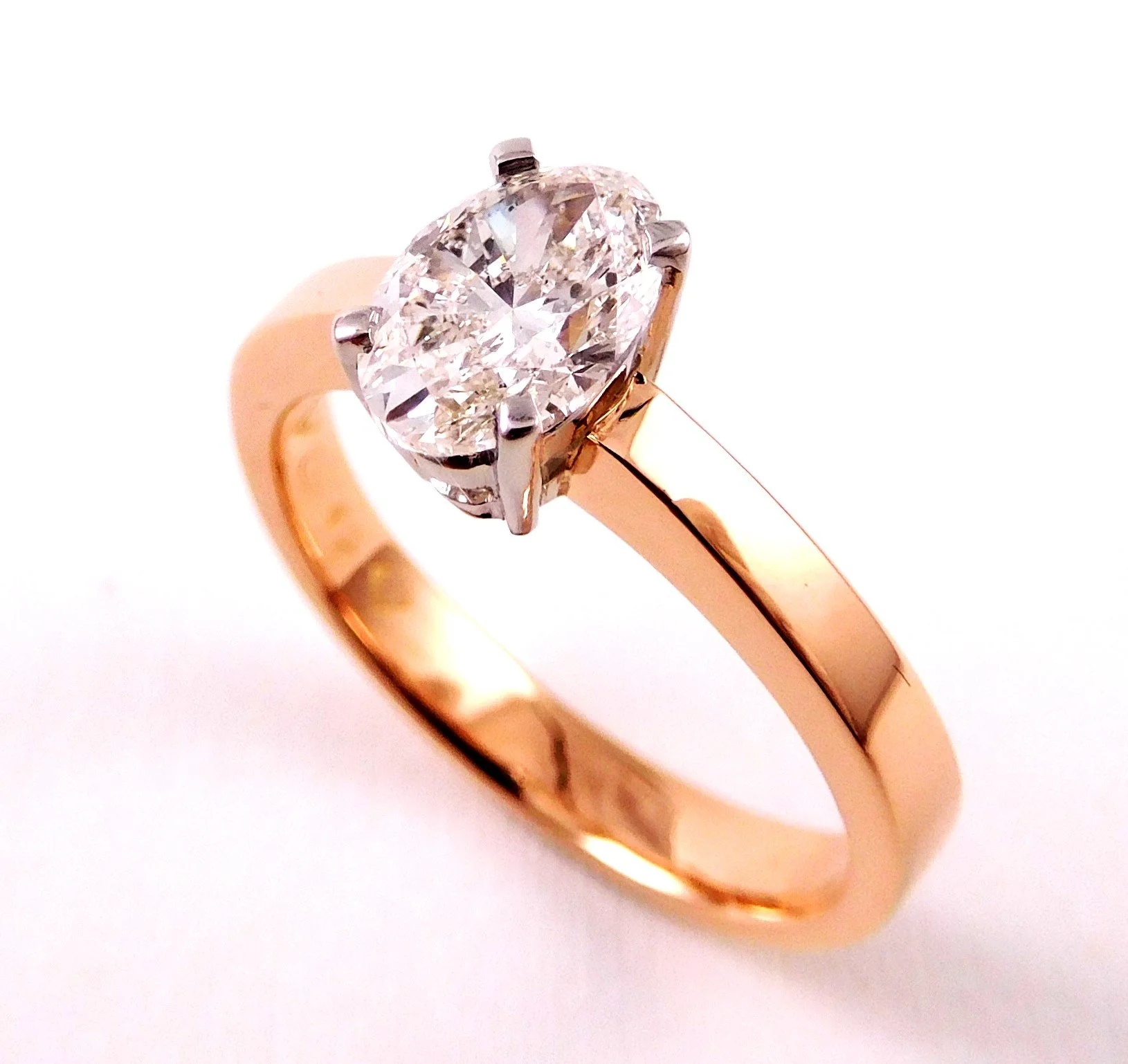 A gold ring with a large round-cut diamond solitaire on a white background.