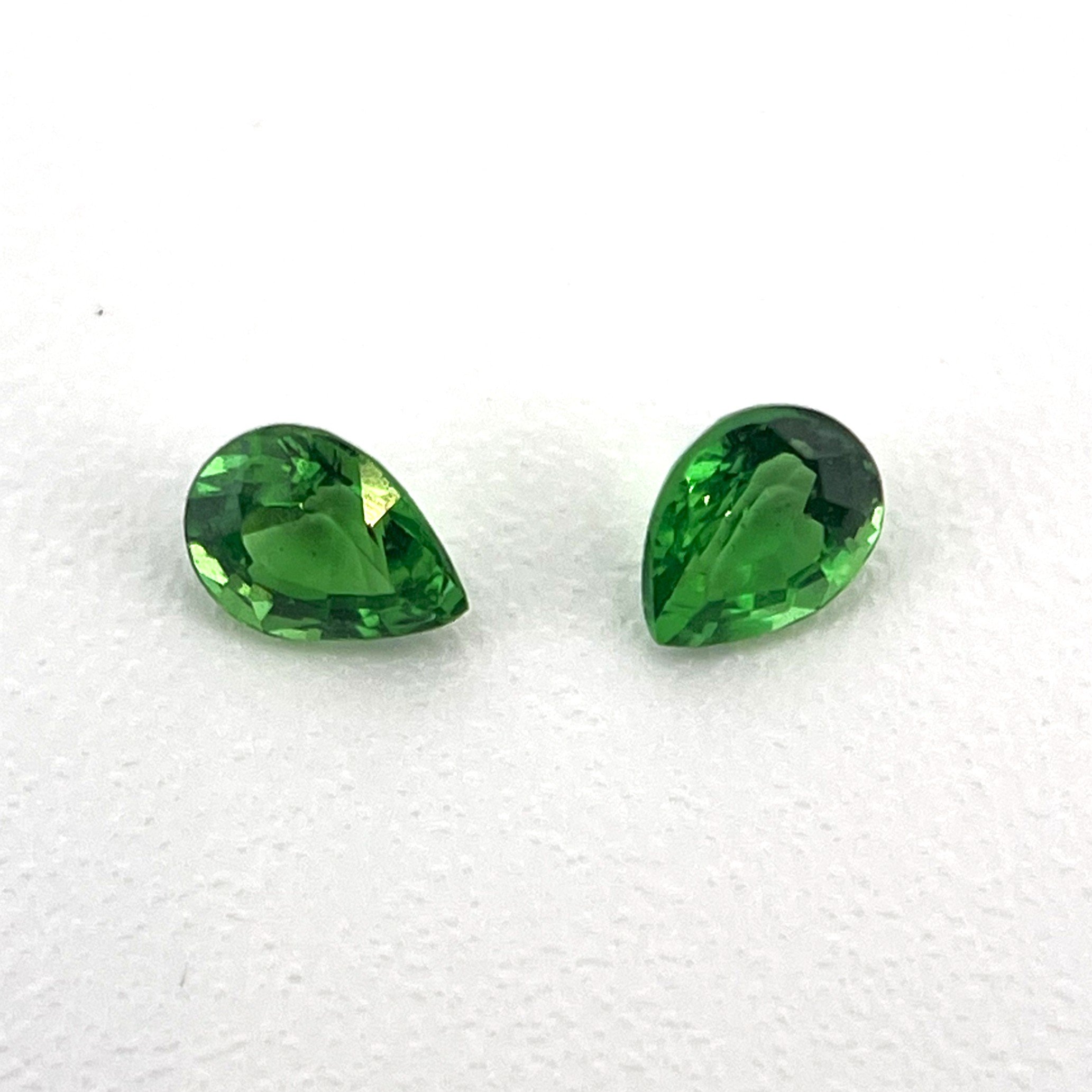 Pair of green tsavorite garnets sourced for the eyes of a bespoke snake cuff