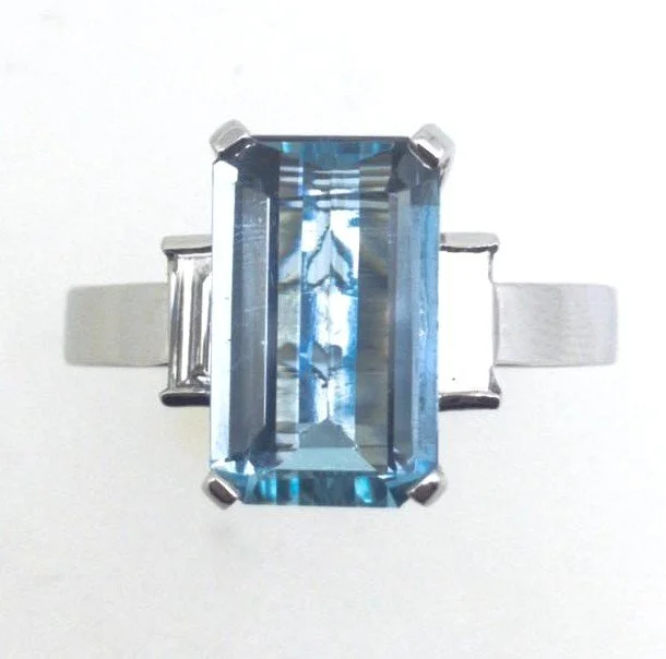 White gold ring with a large rectangular blue aquamarine gemstone with diamonds
