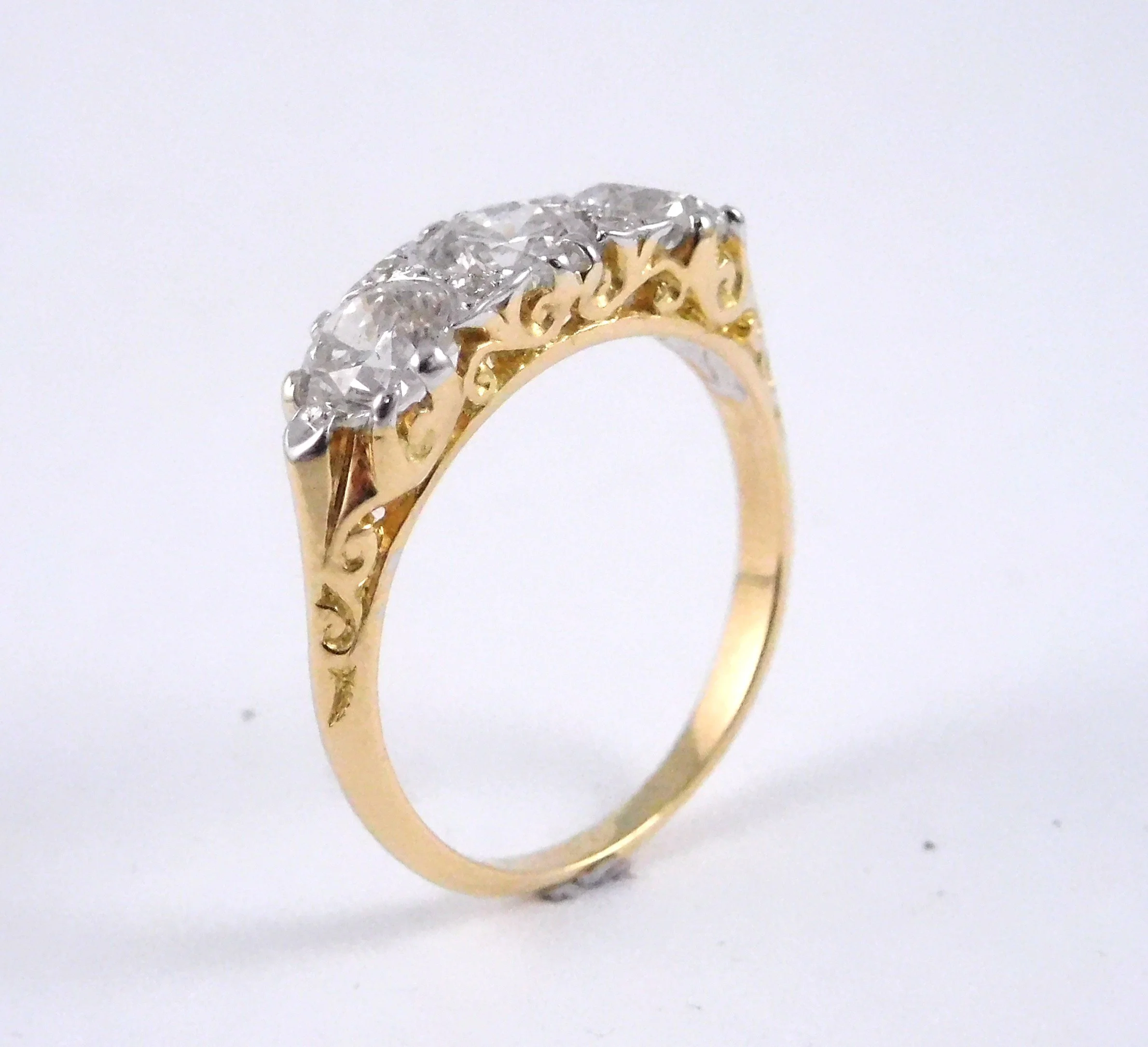 Close-up of a gold ring with a cluster of diamonds set on top, isolated on a white background.