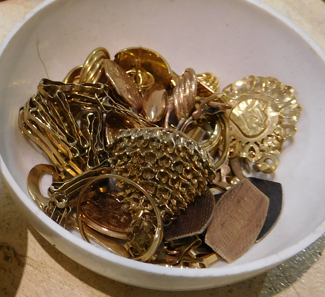 Bowl of old gold jewellery for recycling or metal value assessment