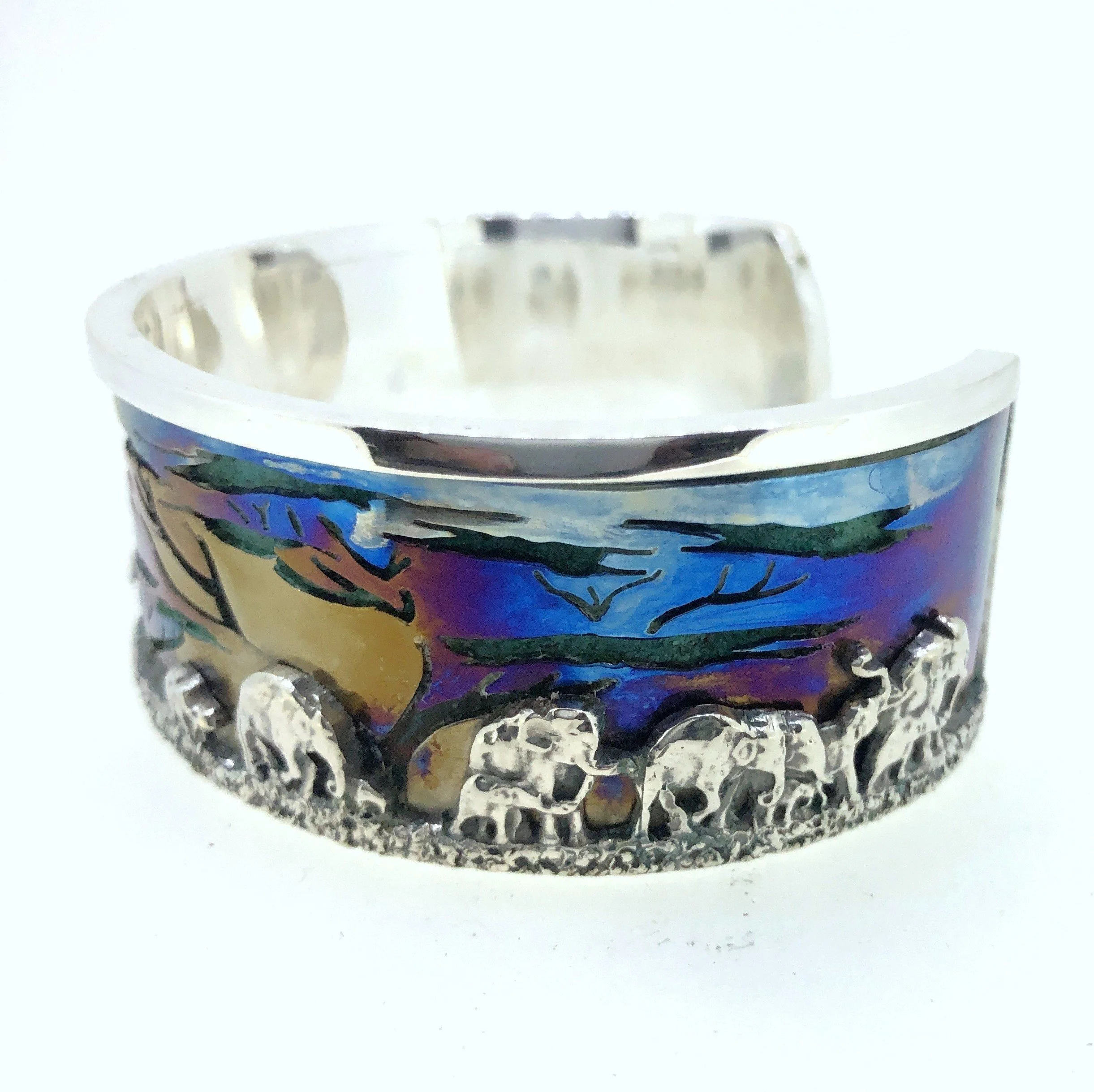 A large sterling silver and titanium cuff, with decorative elephant safari scene inlaid.