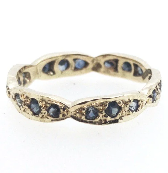 Gold ring with small blue gemstones set around it.