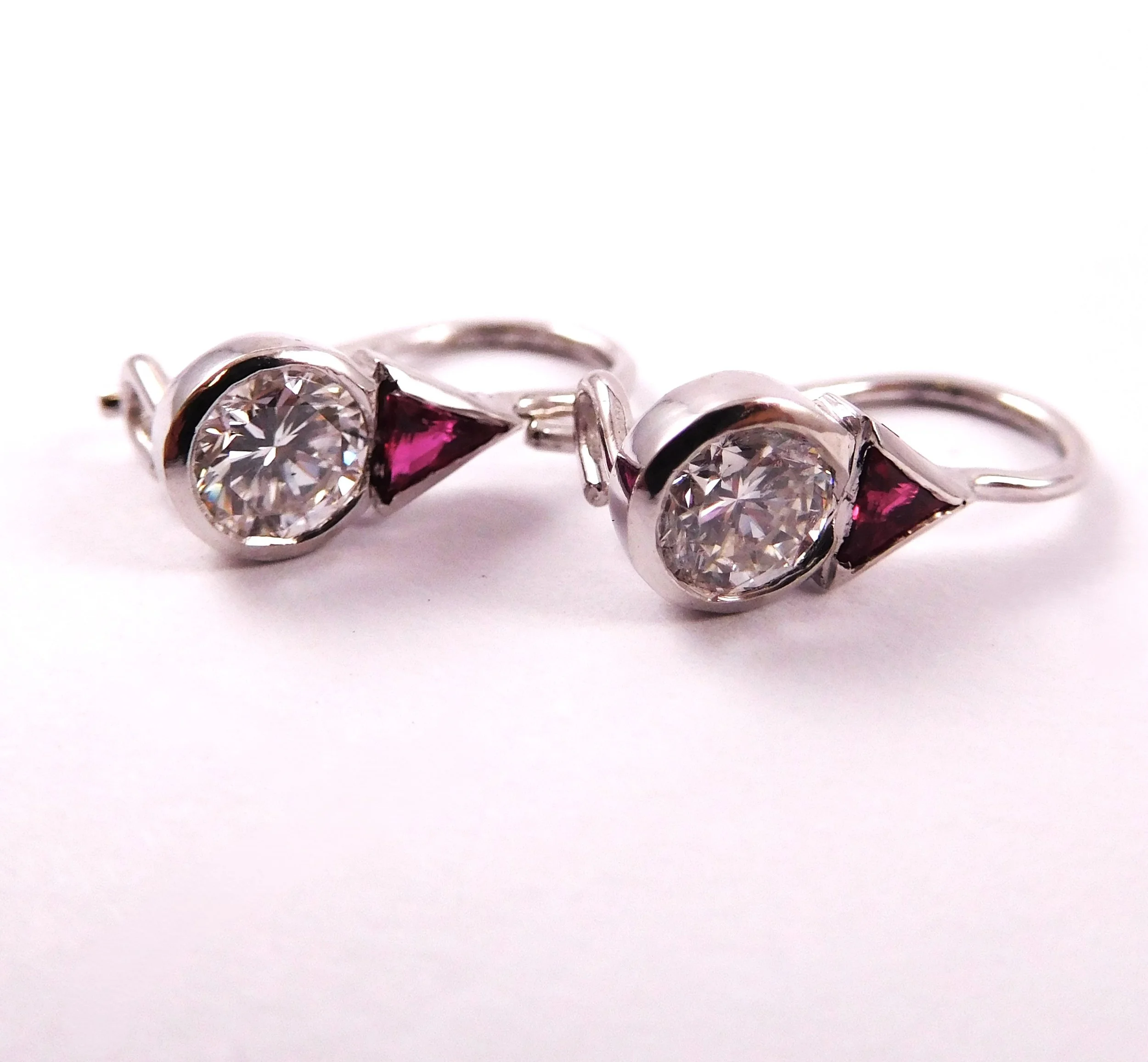 Close-up of white gold earrings with white and pink gemstones