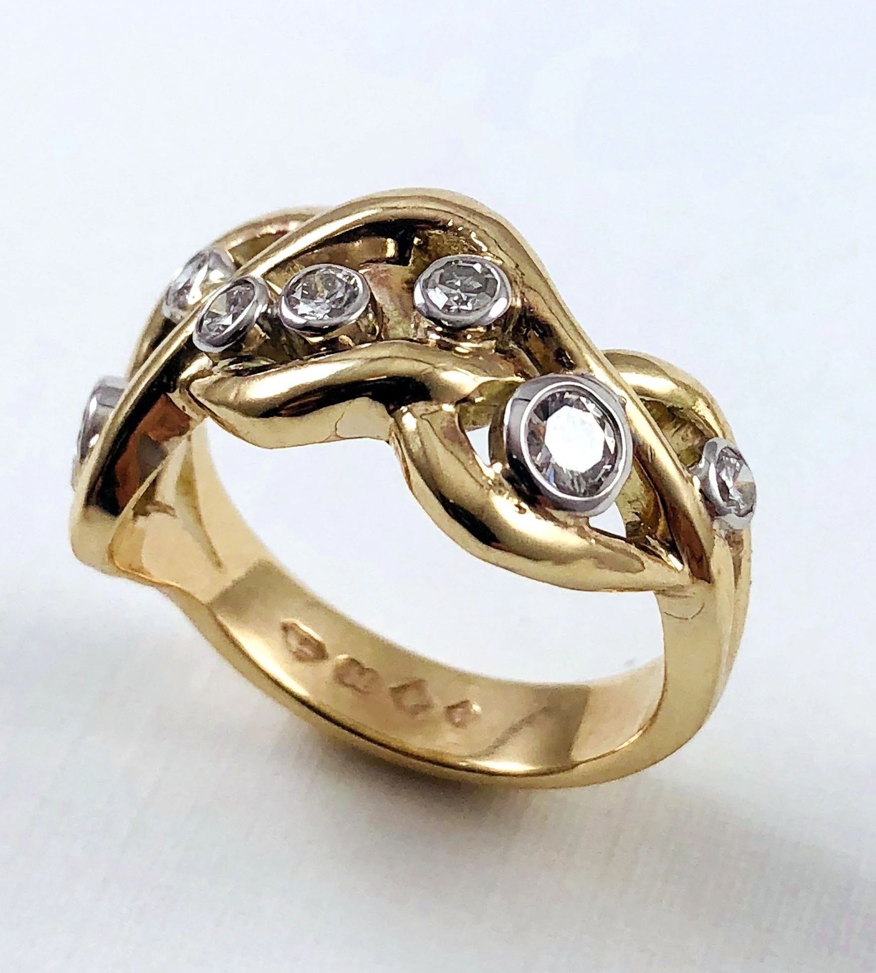 Close-up of a gold ring with multiple round diamonds embedded in a decorative design.