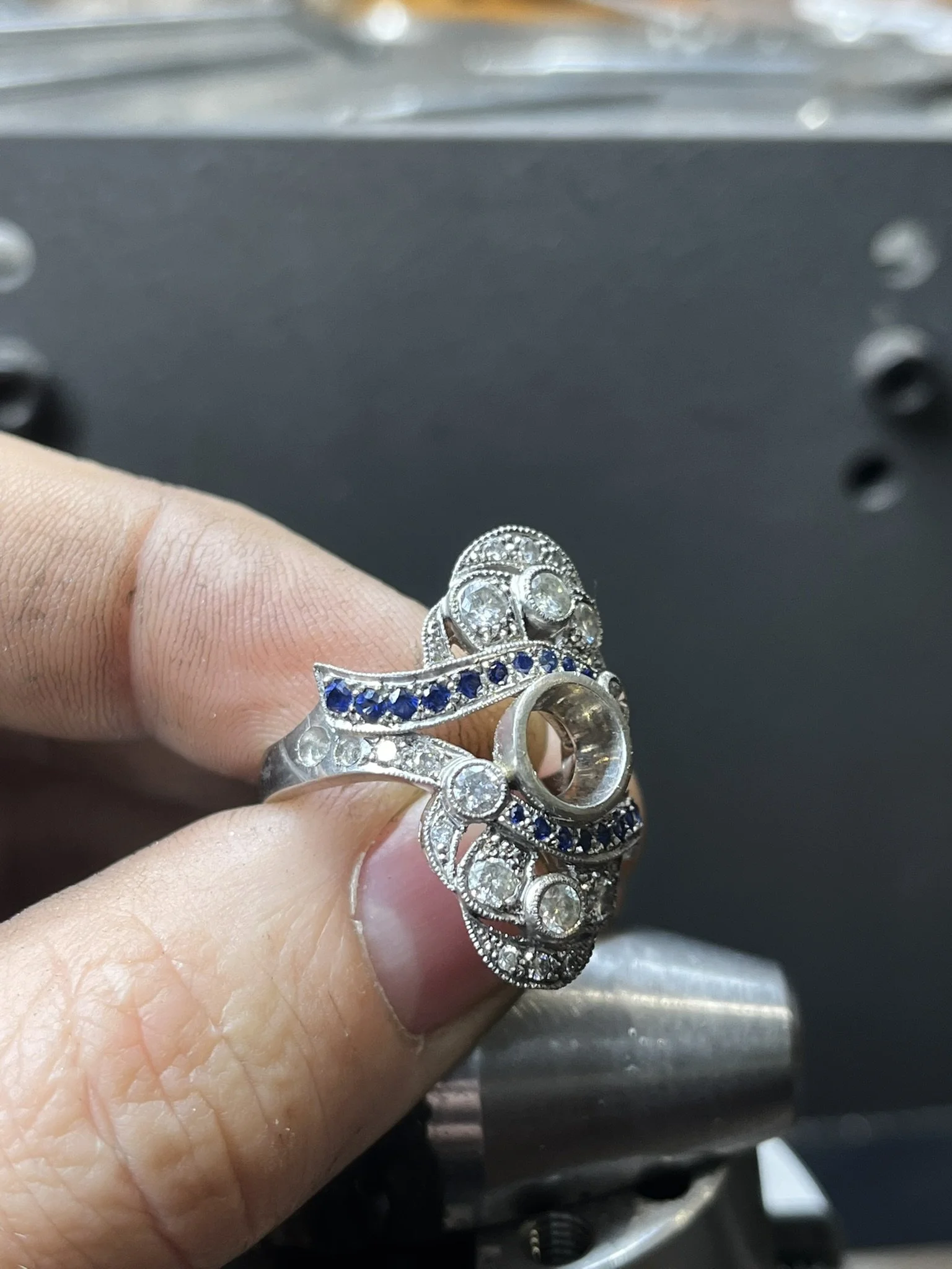 Handmade platinum ring being checked during sapphire and diamond setting
