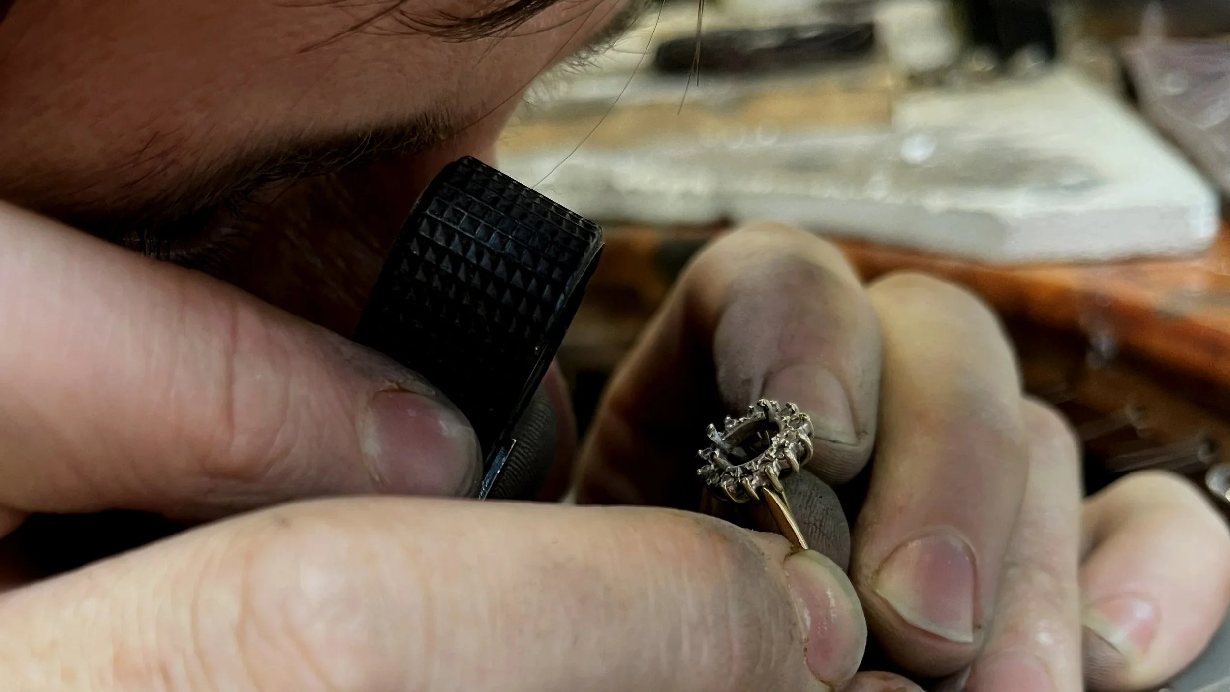 Matthew Neale inspecting a diamond ring repair at the jeweller’s bench