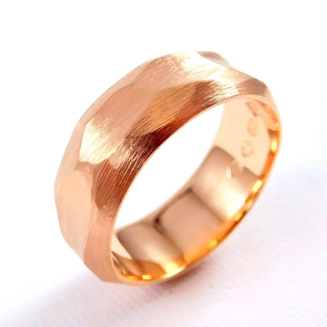 Close-up of a rose gold wedding band with a matte and polished finish