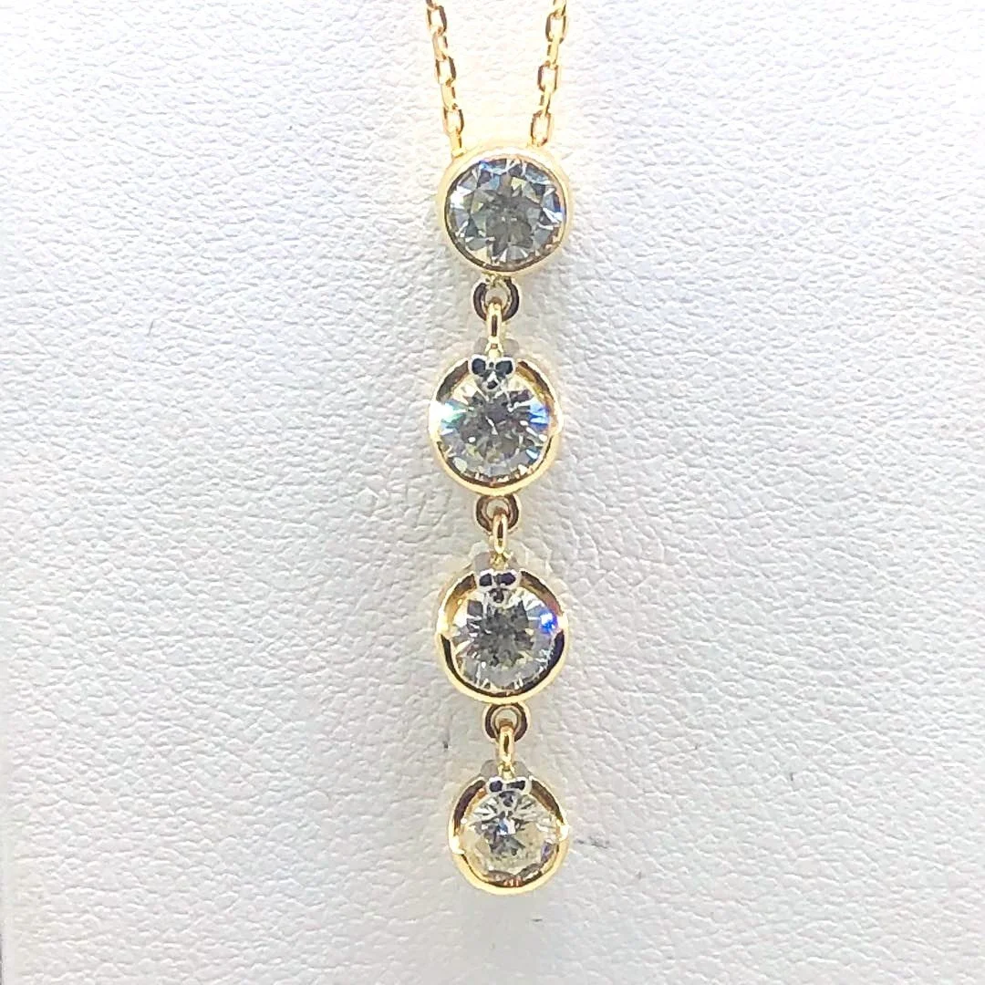 Gold necklace with four dangling round-cut diamonds.