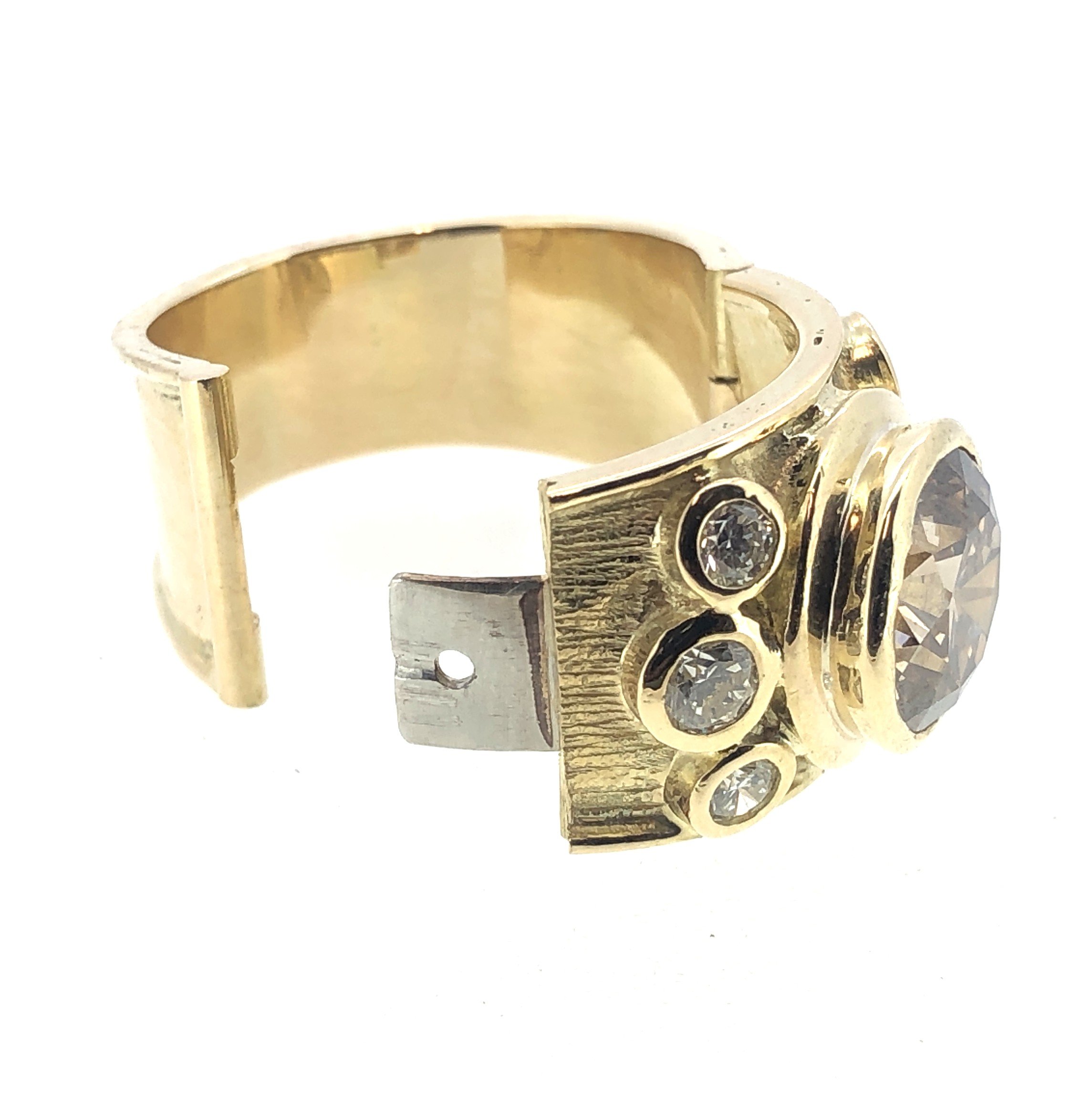 Close-up of a gold and silver ring featuring small gemstones.