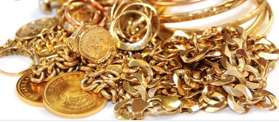 A pile of gold jewelry including coins, rings, and chains.