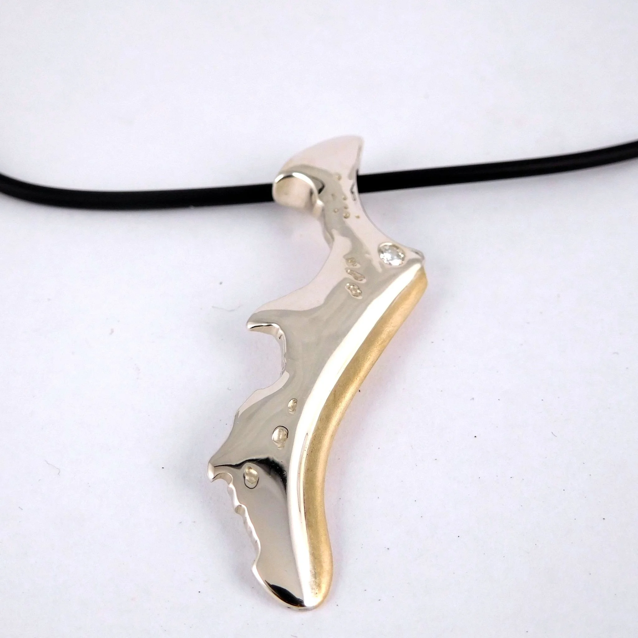 A pendant made out of gold to represent Stradbroke Island. 