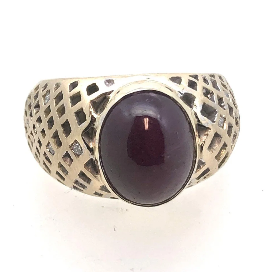Front view of a yellow gold star ruby ring with hand-pierced lattice shoulders