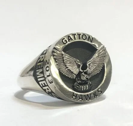 Silver ring featuring a bird with outstretched wings and the words 'GATTON HAWKS' around the top, with a black background.