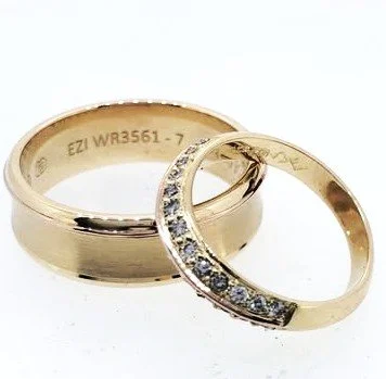 Two gold rings, one plain and one with embedded diamonds, against a white background.